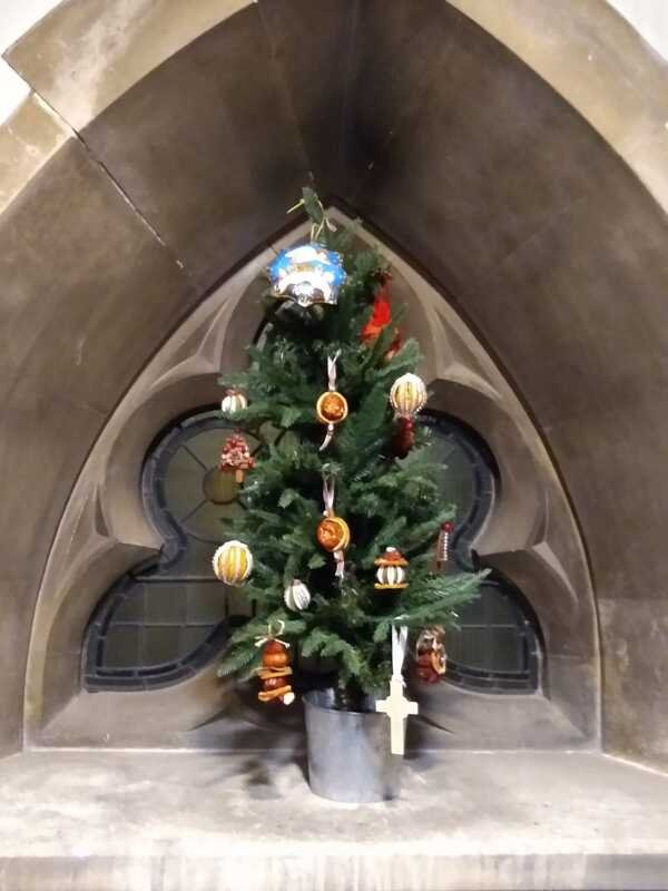 A decorated Christmas tree in a stone arched window recess